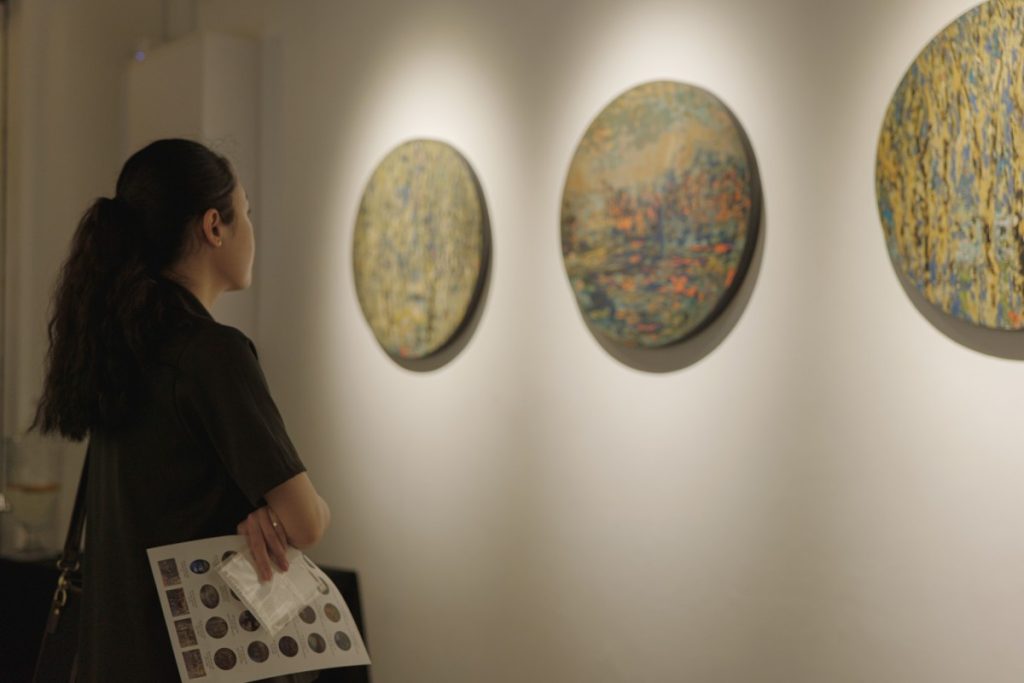 Một cô gái đang xem những tác phẩm của nghệ sĩ Vũ Đức Trung