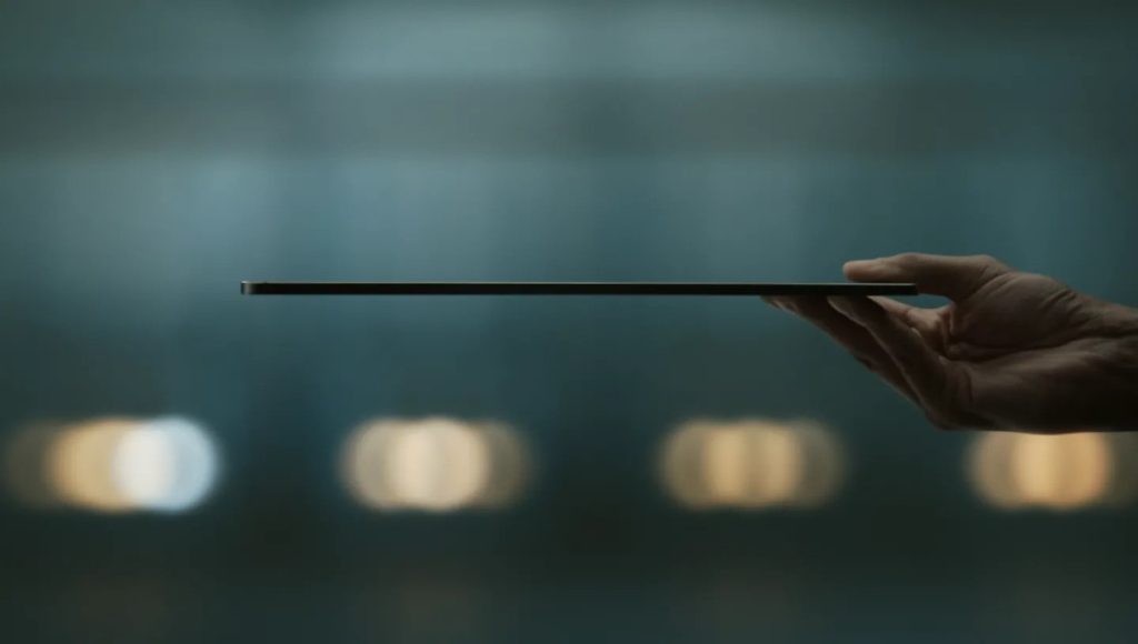 Một cái tay đang cầm chiếc iPad Pro nằm nghiên, mô tả sự mỏng nhẹ