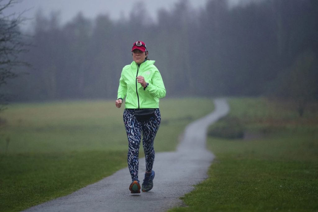Người phụ nữ mặc bộ đồ thể thao đang chạy bộ bán Marathon trên con đường mòn