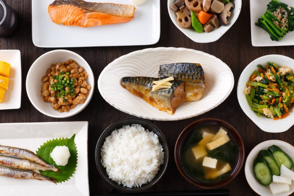 Bữa ăn minh hoạ phong cách ẩm thực washoku với cá, cơm canh, rau củ xào