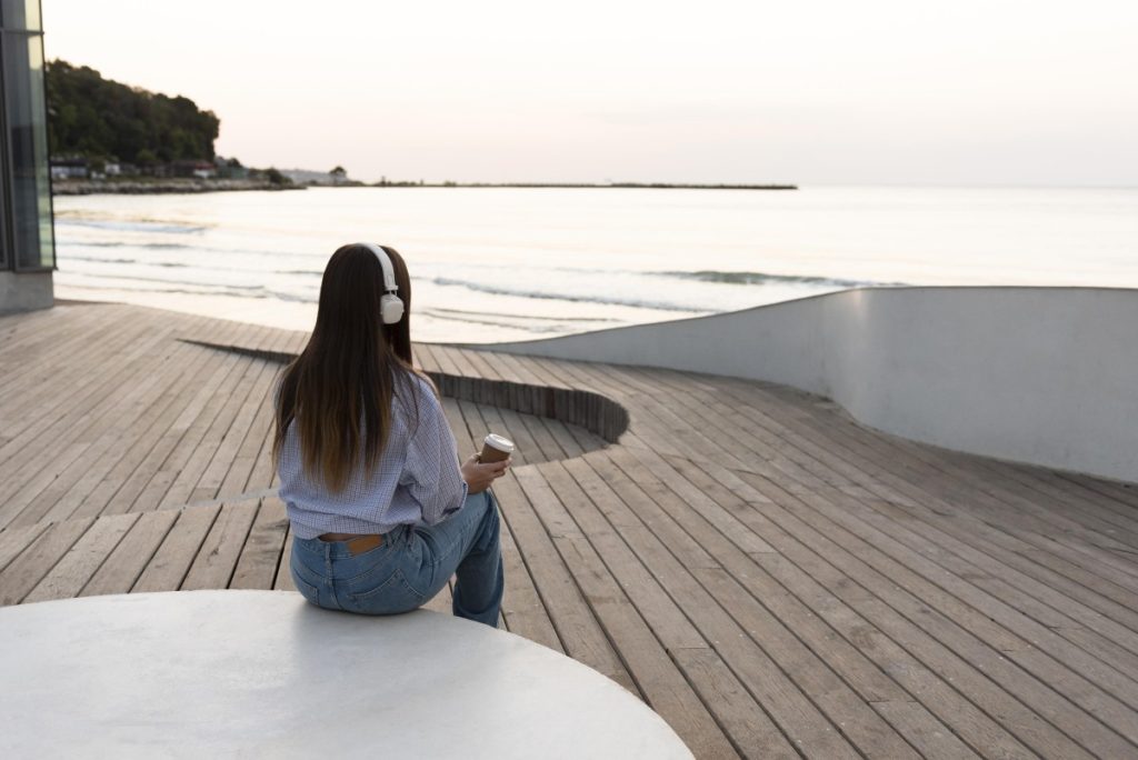 back view woman relaxing while wearing headphones