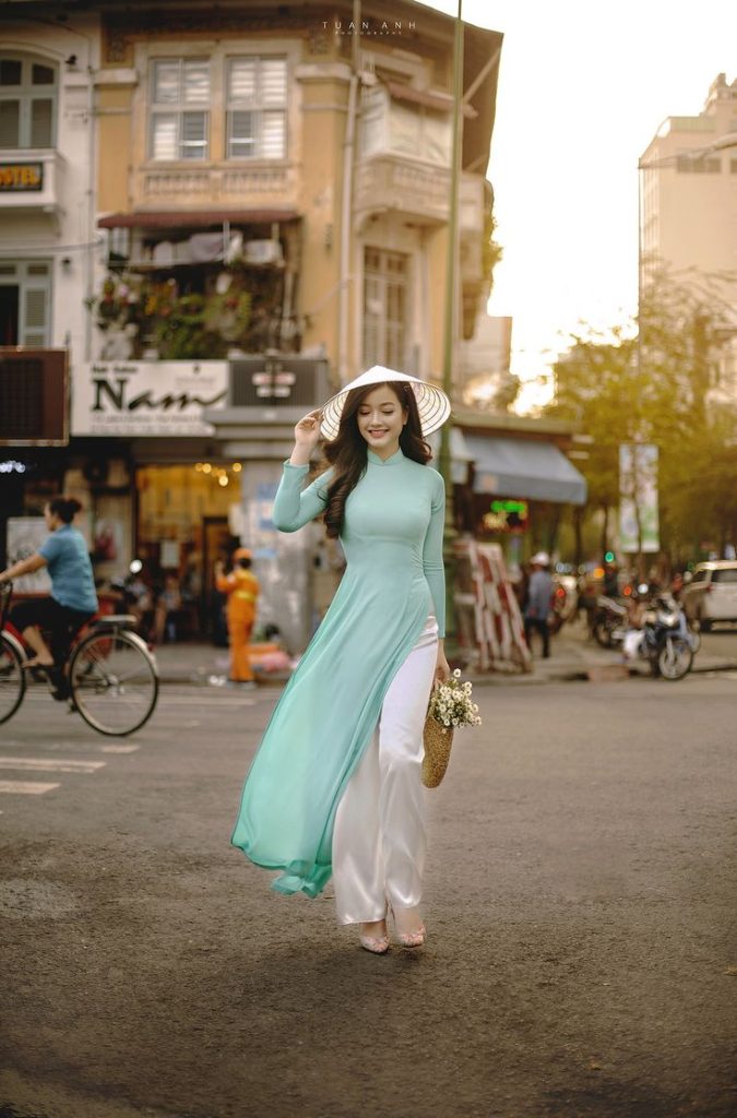 nguoi nu mac ao dai viet nam xanh da troi di tren duong